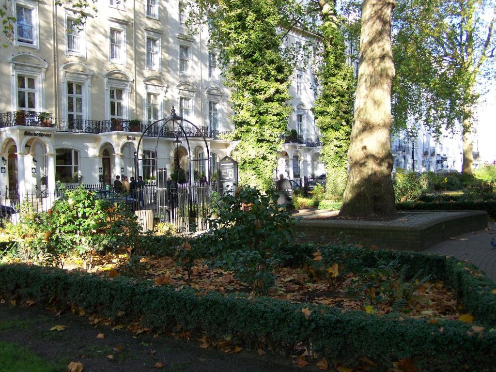 伦敦托尼之家酒店的白色的建筑,有栅栏和树