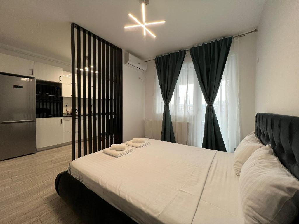 雅西Perfect Host Palas的一间带白色大床的卧室和一间厨房