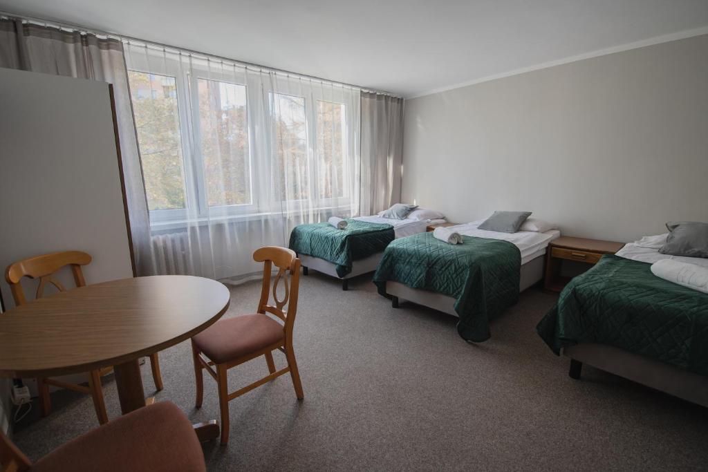 克拉科夫费利克斯酒店的一间设有两张床和一张桌子及椅子的房间