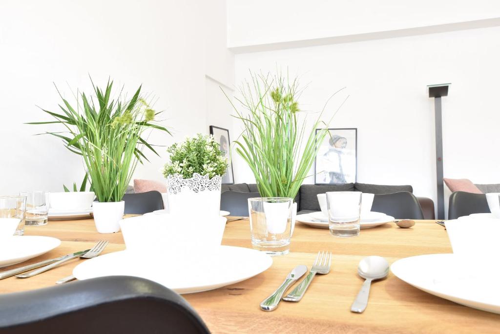 因斯布鲁克Riesiges zentrales Apartment mit Parkplatz的一张木桌,上面有白板和银器,还有植物