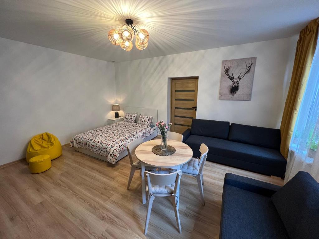 卡托维兹Wood Apartment z Konsola X-Box的客厅配有沙发、桌子和床。