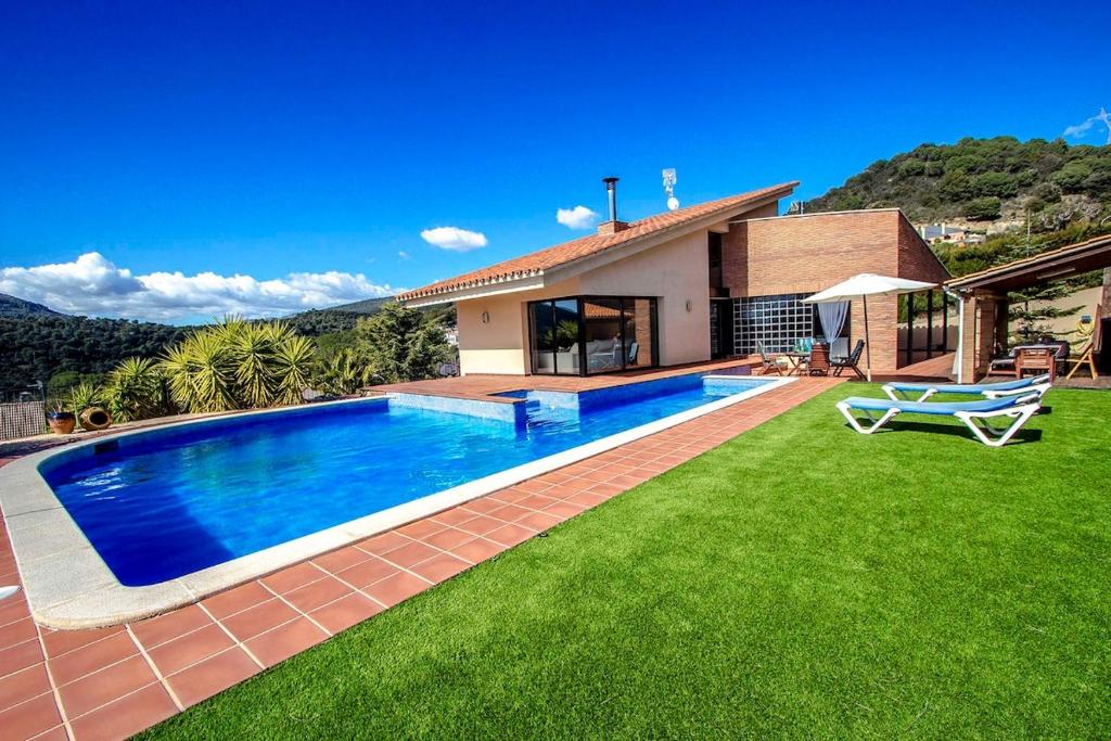 卡尔德斯德蒙特维Catalunya Casas Stunning modern villa and just half hour to Barcelona!的一座房子的院子内的游泳池