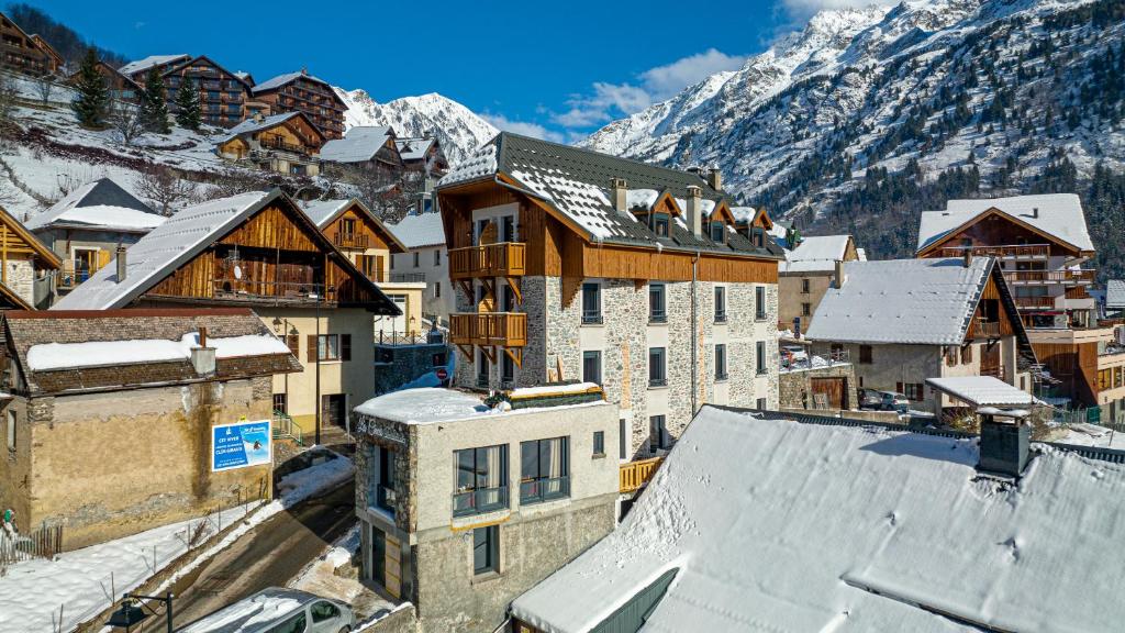 沃雅尼Madame Vacances Hotel Les Cimes的享有小镇空中景色,拥有雪覆盖的建筑
