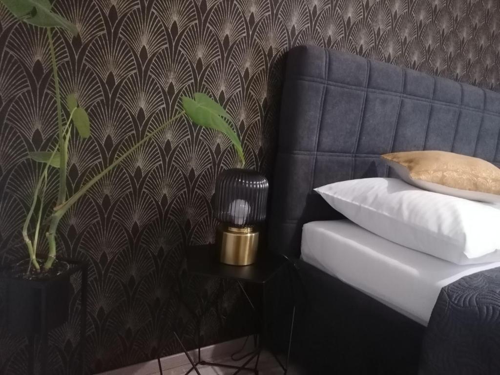 斯拉沃尼亚布罗德Apartman Lipa的一张带枕头的床和墙上的植物