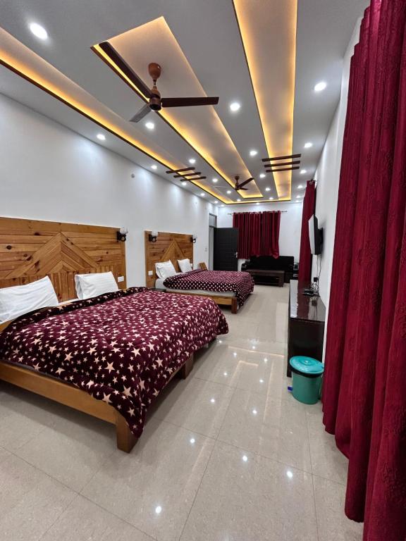 恰克拉塔HOTEL HIMALAYAN FOXHOLE的一间卧室设有两张床和红色窗帘
