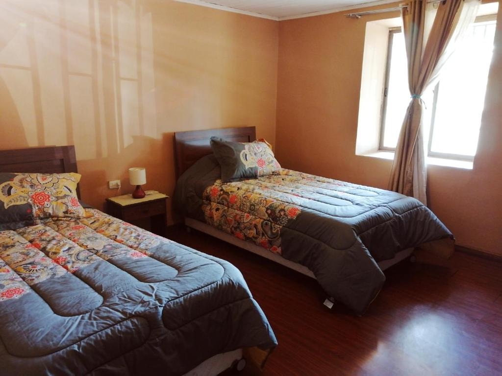帕尼马维达Hostel Casa Descanso Natural的一间卧室设有两张床和窗户。