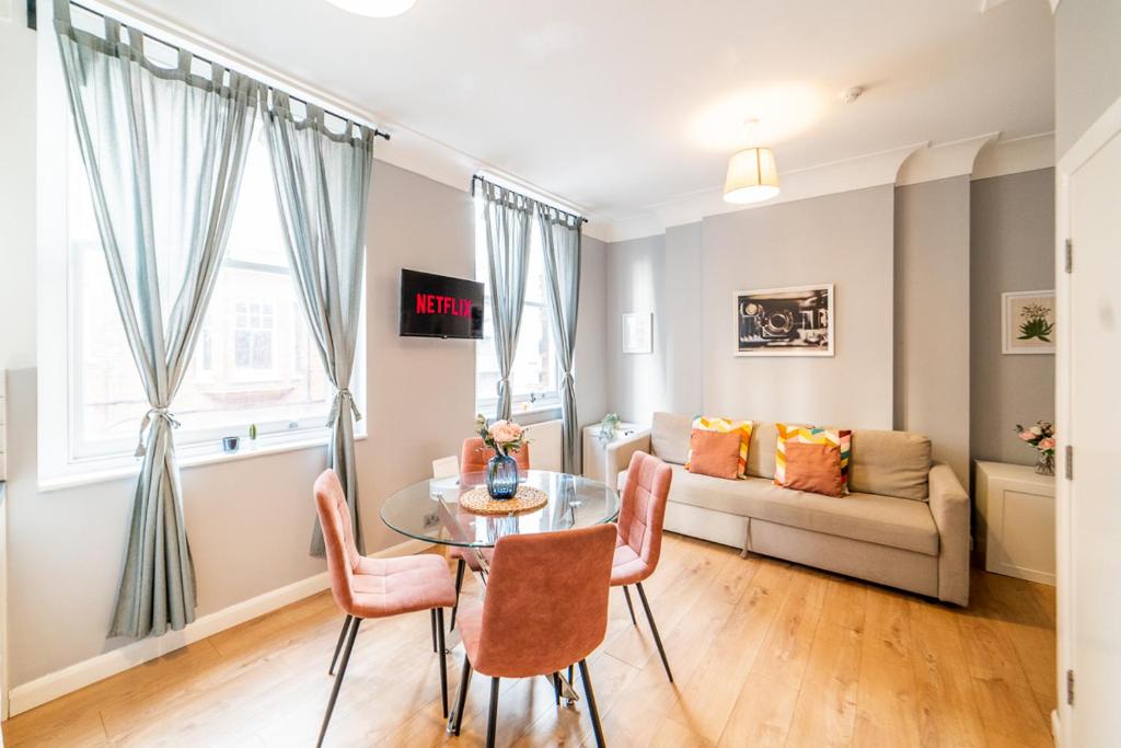 伦敦［FITZROVIA-COVENT GARDEN］CENTRAL LONDON APARTMENT的客厅配有桌子和沙发