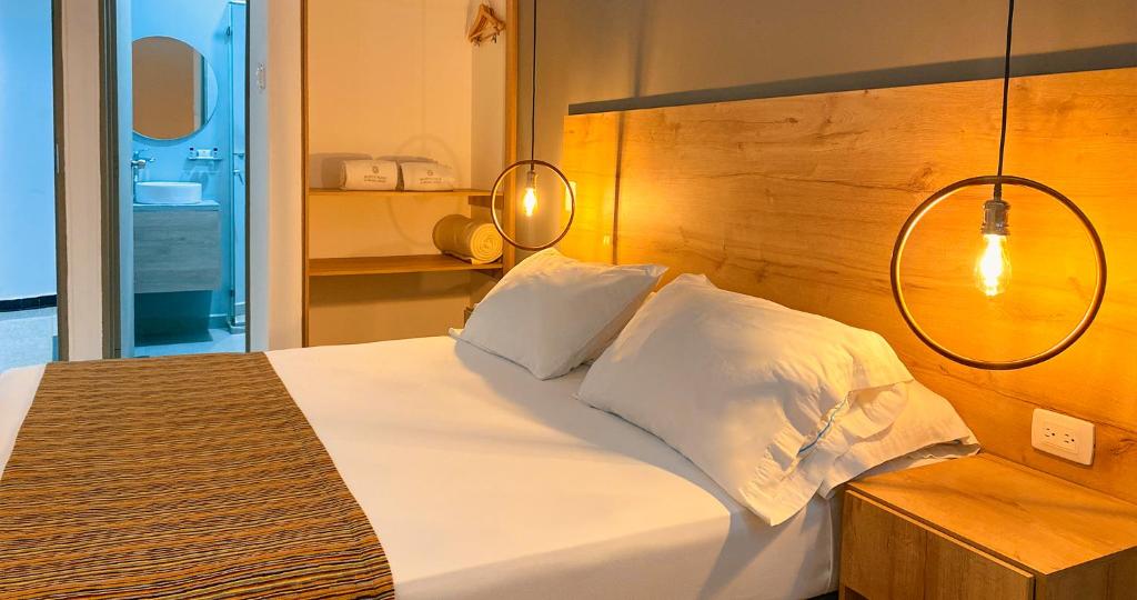 布卡拉曼加Hotel Ruittoque D Prada的卧室配有白色的床和木制床头板