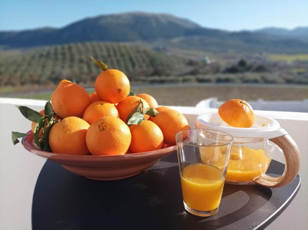 特拉武科新镇Casa Celeste Trabuco的桌上放一碗橘子,放上一杯橙汁