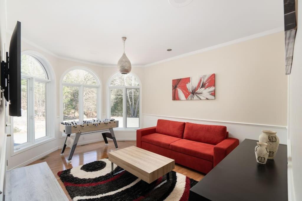 莫兰高地Majestic Retreat in the Laurentians的客厅配有红色的沙发和桌子