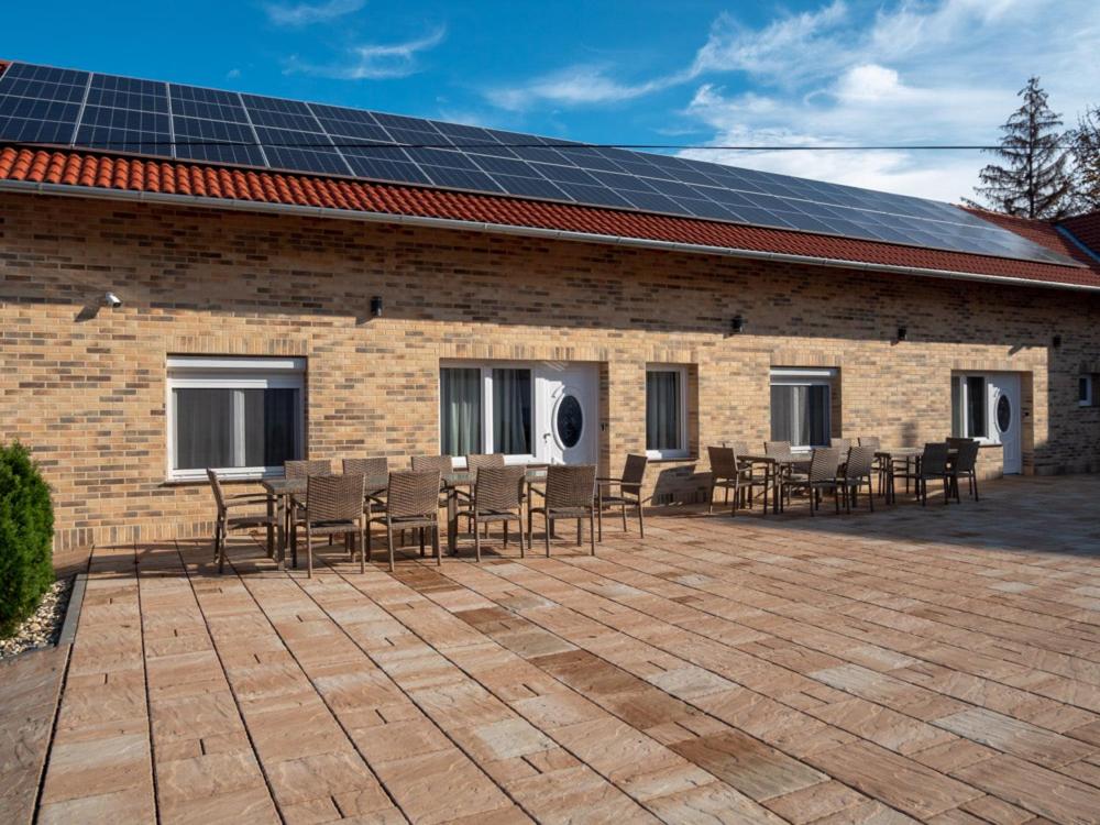 维拉尼Andoravendégház - Villány的屋顶上设有椅子和太阳能电池板的建筑
