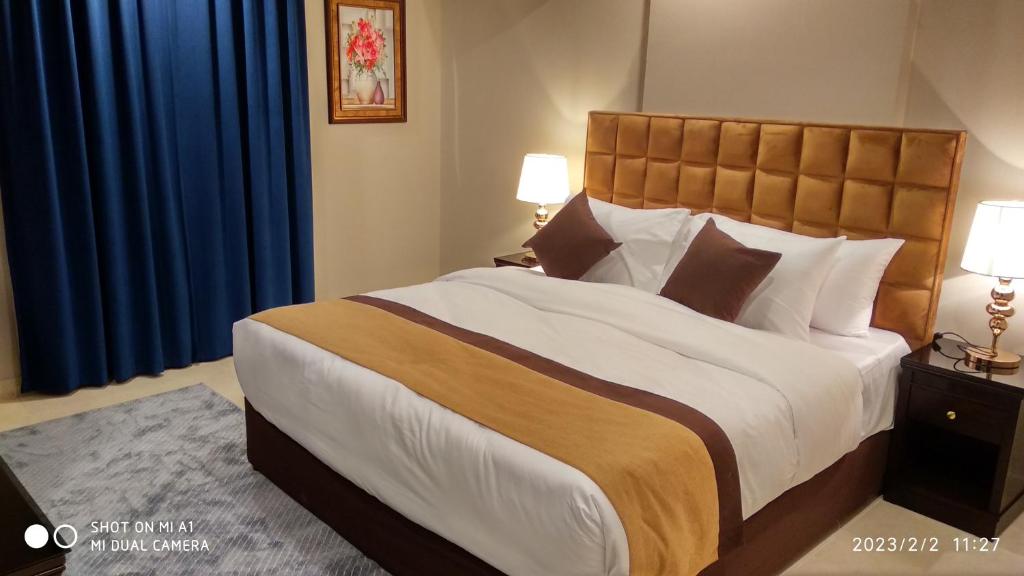 吉达Yan Apartments的一间卧室配有一张带蓝色窗帘的大床