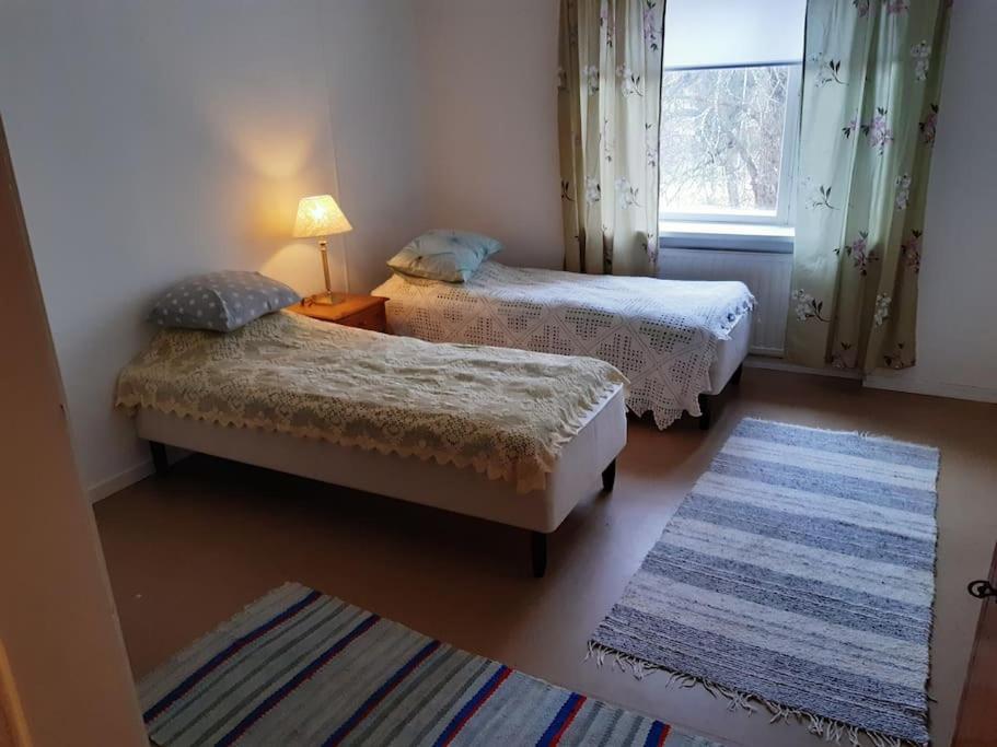 科科拉Willa Witsari 65m2 asunto的客房设有两张床、一个窗户和一个地毯。