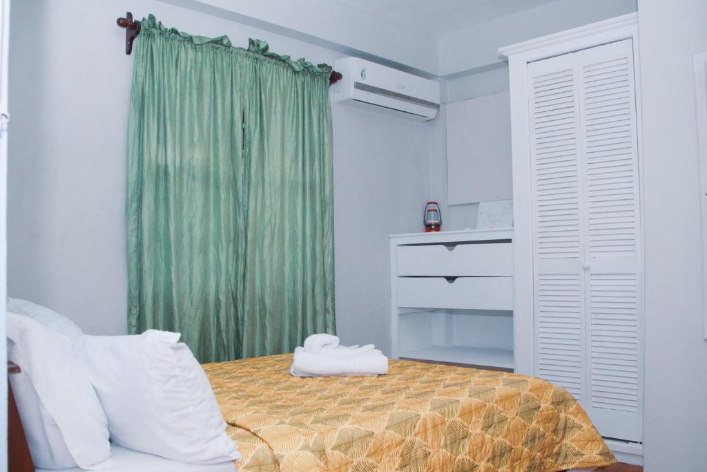 Arnos ValeButtercup Cottage Apartments的一间卧室配有床和绿帘