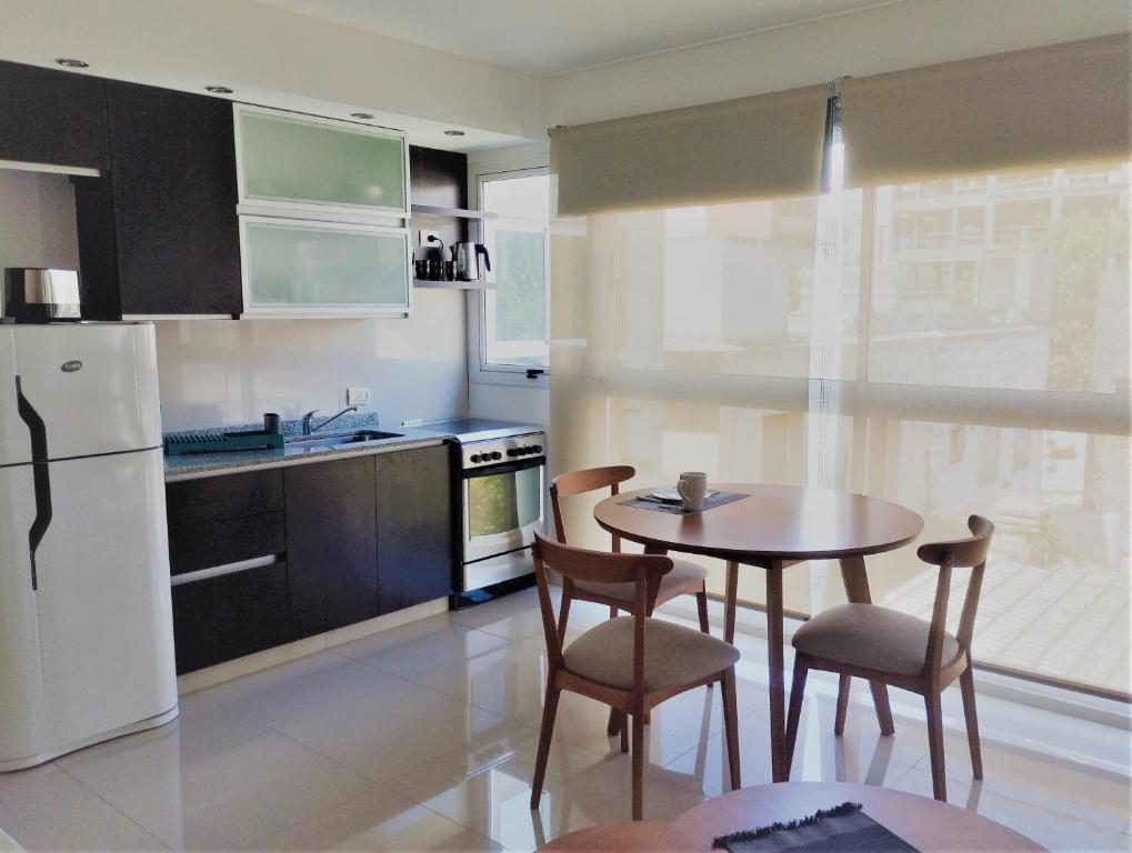 布宜诺斯艾利斯Blue Bird Studio Baires的厨房配有桌椅和白色冰箱。