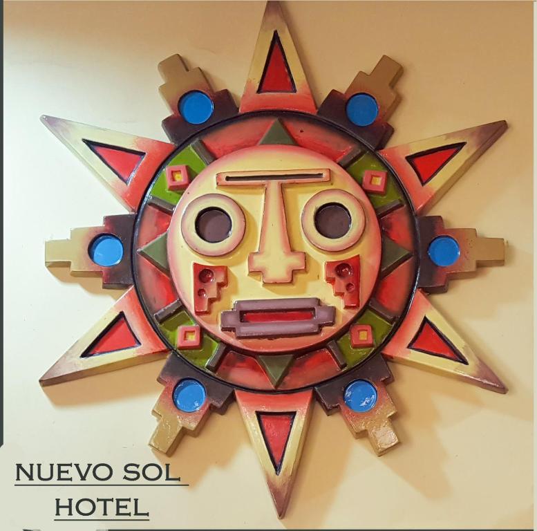拉巴斯Hotel Nuevo Sol的挂在墙上的木制太阳钟