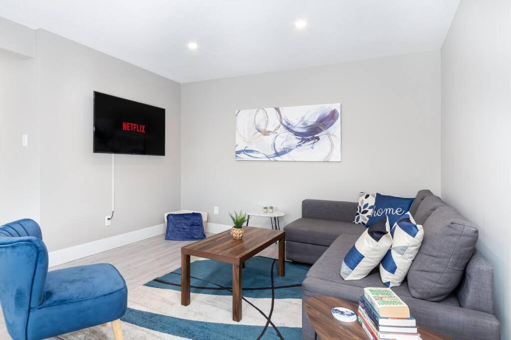 埃德蒙顿Modern & Elegant 1-Bedroom Unit的客厅配有灰色的沙发和蓝色的椅子