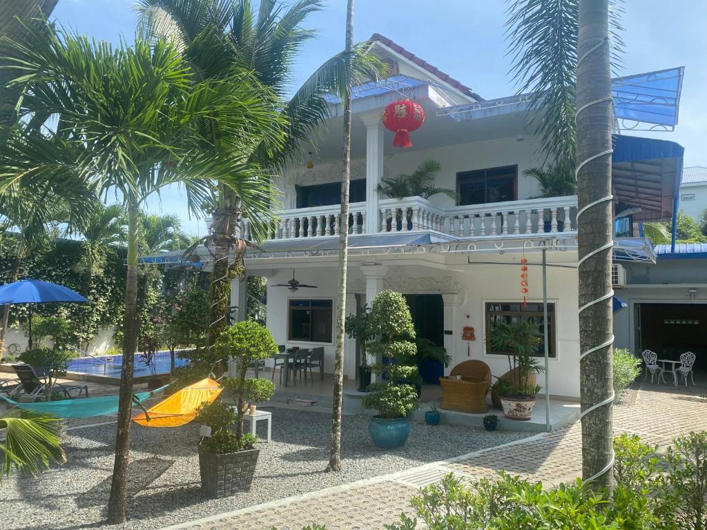 西哈努克Villa Blue Lagoon的一座带游泳池和棕榈树的房子