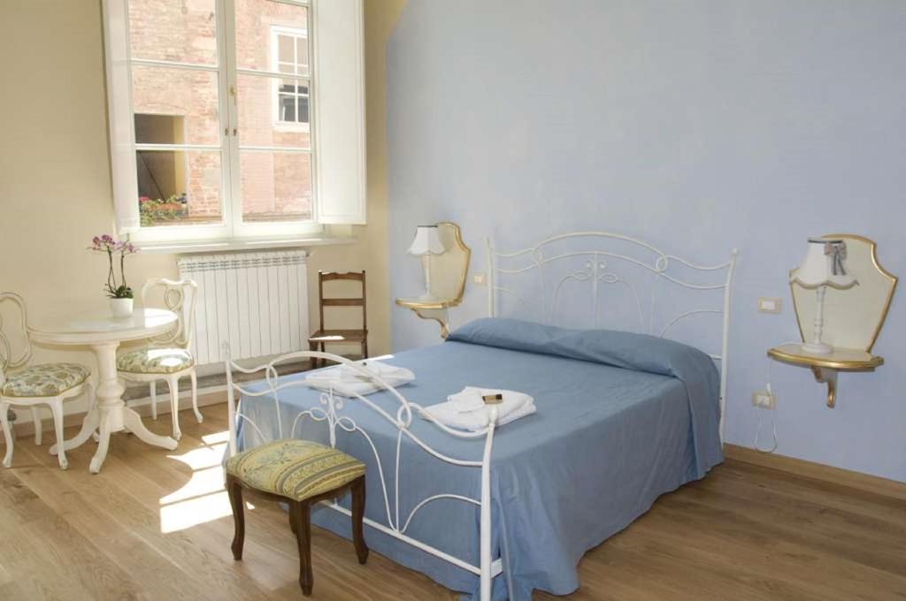卢卡安菲堤亚特洛B&B酒店的一间卧室配有蓝色的床和桌椅