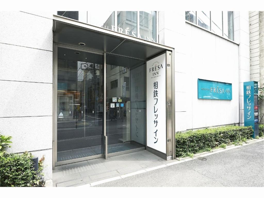 东京Sotetsu Fresa Inn Shimbashi-Karasumoriguchi的玻璃门进入大楼的入口