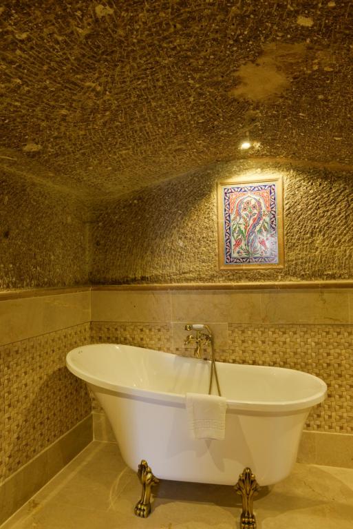 格雷梅Goreme Suites by AZA的带浴缸的浴室和马赛克墙