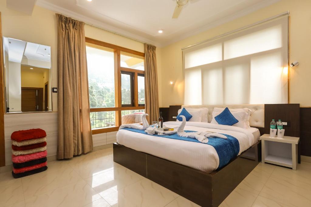 达兰萨拉Hotel yellow nest inn的一间卧室配有一张大床和毛巾