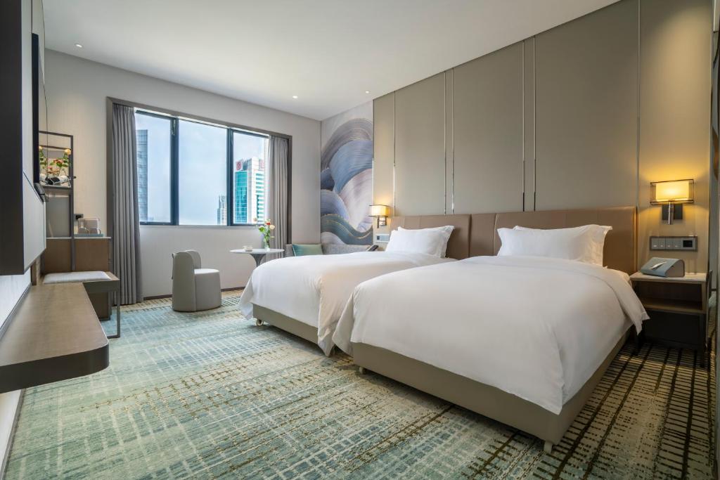 广州广州维多利酒店的酒店客房设有两张床和大窗户。