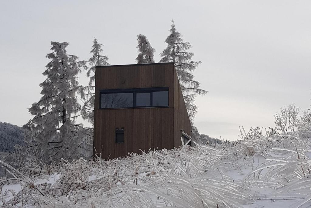 Domek na wzgórzu的一座小建筑,位于一座雪覆盖的山顶上