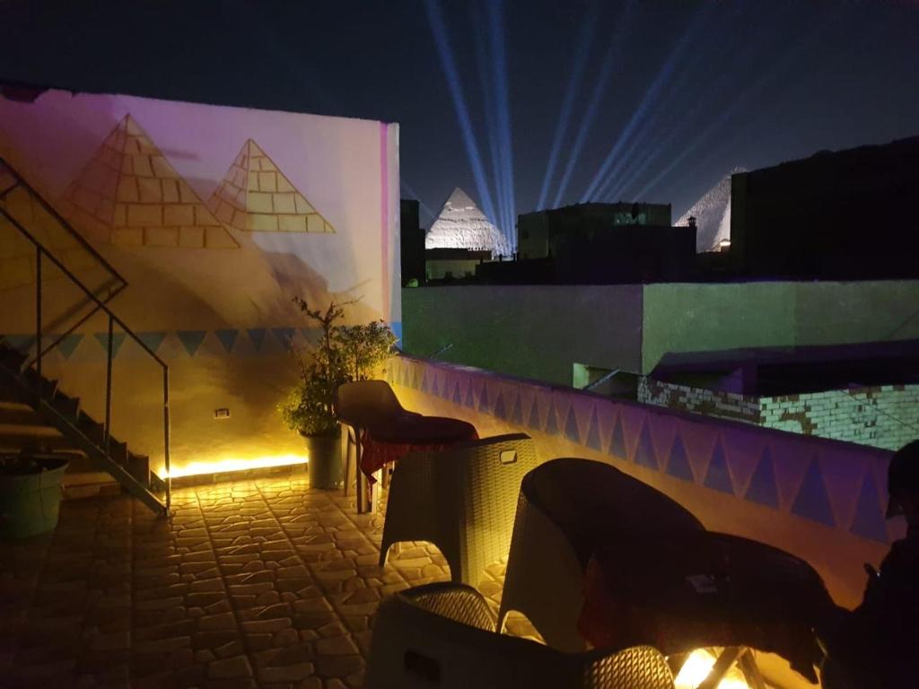 开罗Jana Pyramids view inn的一个带椅子的房间和一个带灯的墙壁