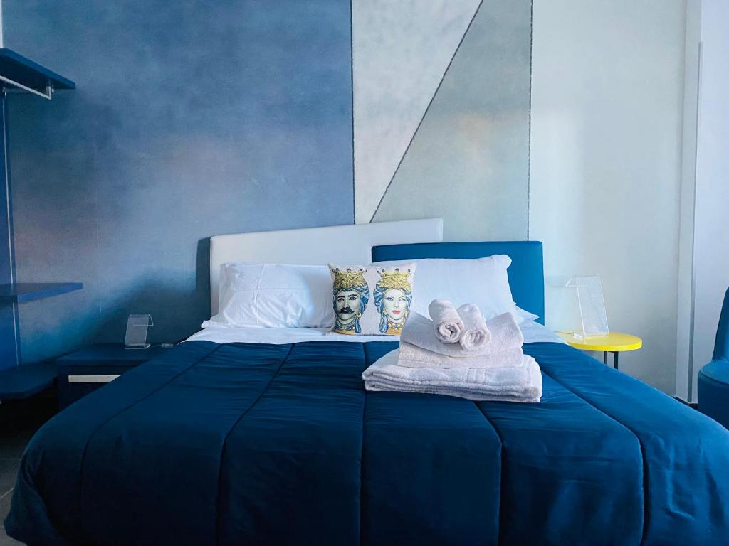 锡拉库扎I Cinque Mori DEVA的蓝色的床,上面有毛巾