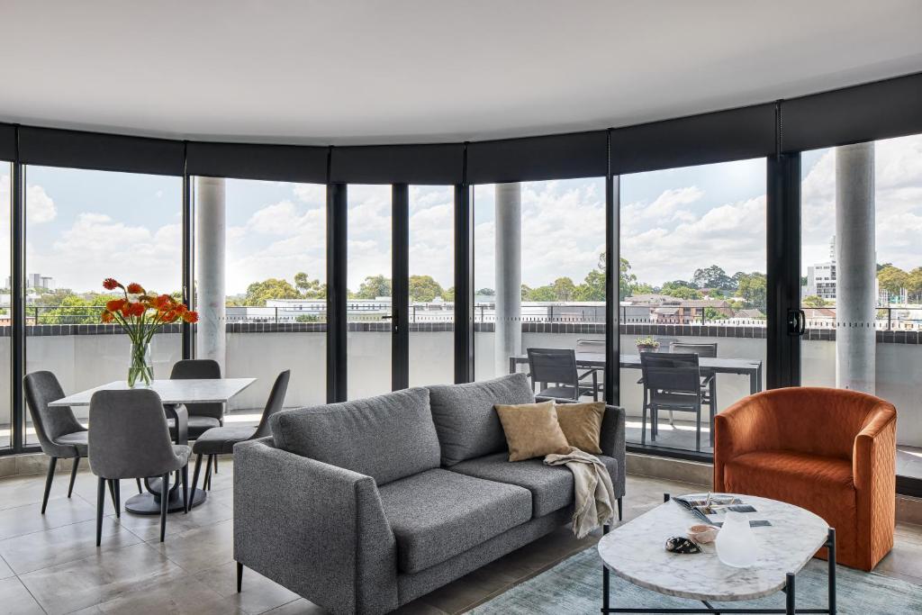 悉尼Punthill Parramatta的客厅配有沙发和桌椅