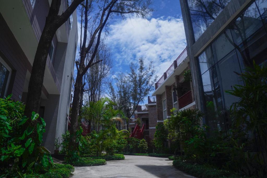 库克斯巴扎DERA Resort & Spa的绿树成荫的建筑与蓝天之间的小巷