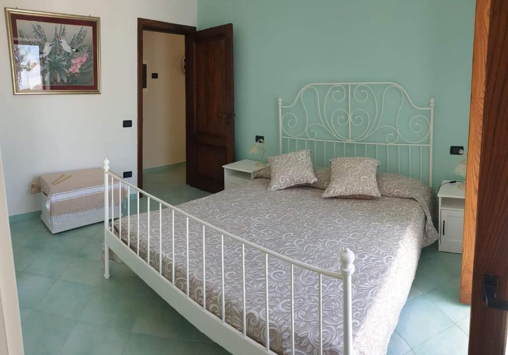 伊斯基亚La Casetta nel Bosco的一间卧室配有一张白色床和绿色床头板
