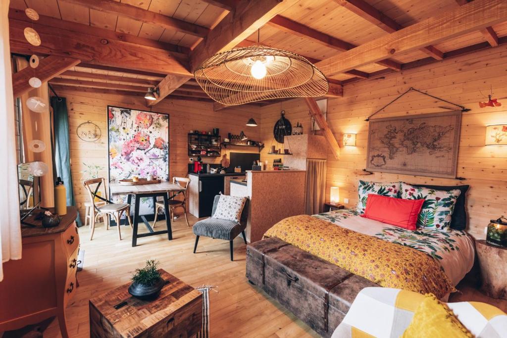 拉瓦勒La cabane du bon chemin ,spa的一间带一张床和一张书桌的卧室和一间厨房