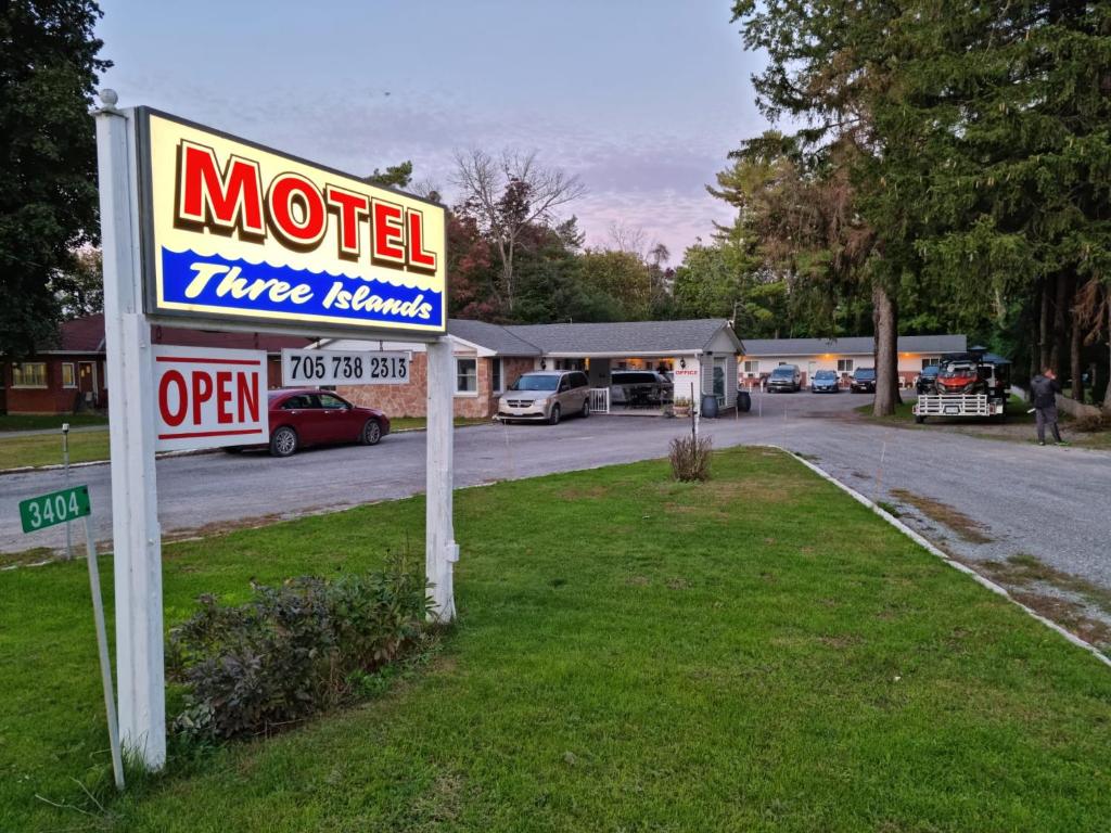 BobcaygeonThree Island Motel的停车场前的汽车旅馆标志