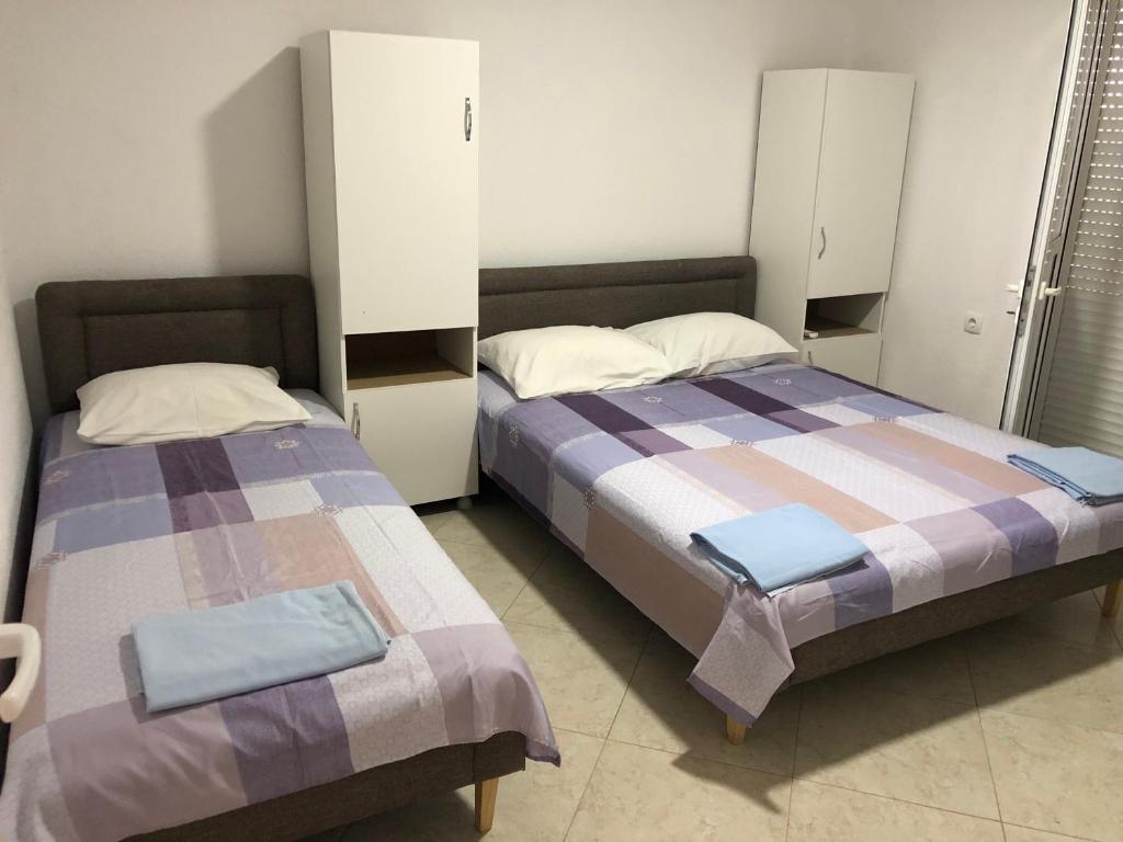 乌尔齐尼Apartments Beho的两张睡床彼此相邻,位于一个房间里