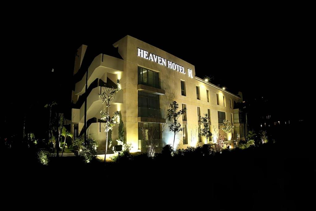 朱尼耶Heaven Prestige Hotel的一座建筑,晚上有哈拉里世界的标志