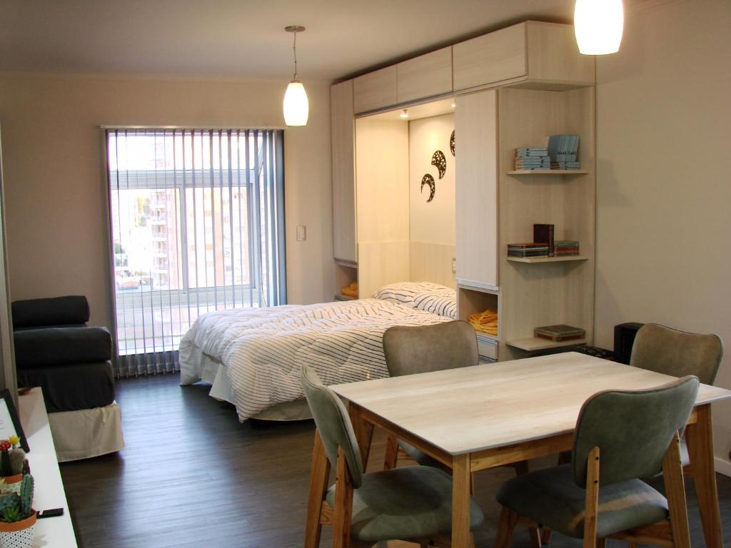 圣罗莎Departamento Rivadavia的卧室配有一张床和一张桌子及椅子