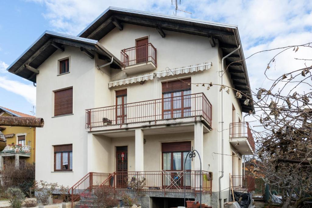 比耶拉Appartamento vista Alpi biellesi的白色的建筑,设有红色的阳台
