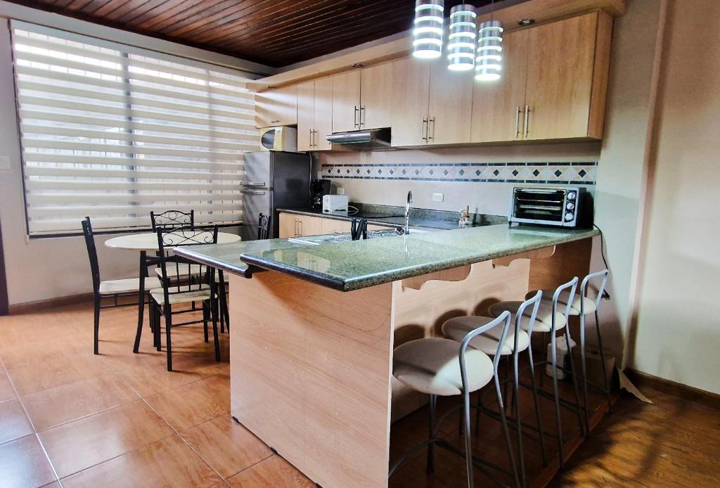 MacasTU CASA EN MACAS的厨房配有柜台和桌椅