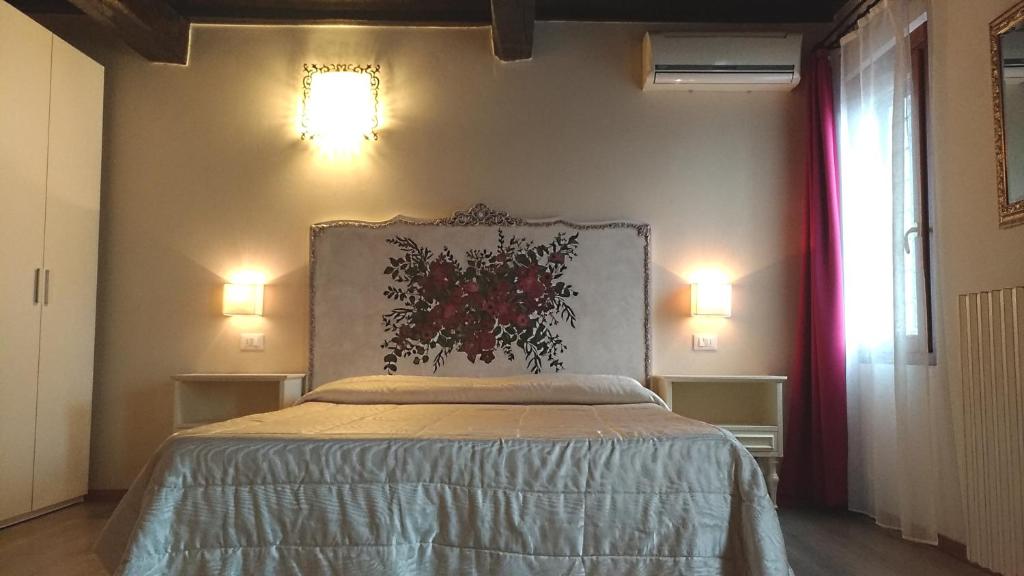 曼托瓦奇塔代拉B＆B别墅酒店的卧室配有一张床,墙上有两盏灯