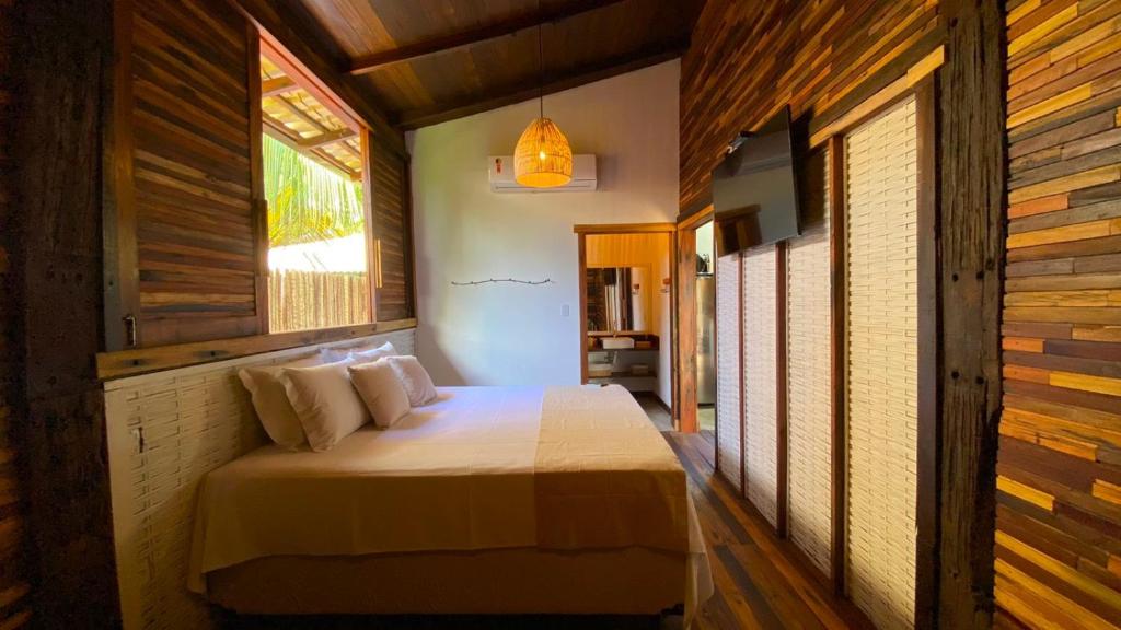 马劳Akua Bungalows的卧室配有一张床铺,位于带木墙的房间内