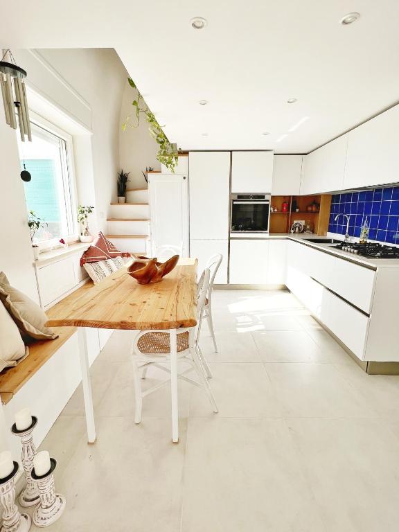 阿纳卡普里Casa Maddy Anacapri的厨房配有木桌和白色橱柜。