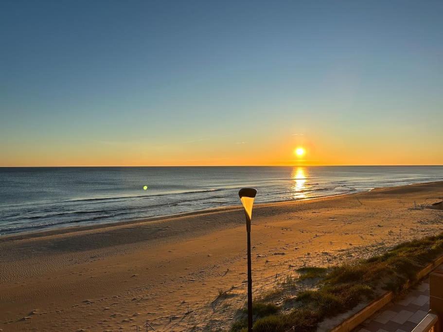 苏埃卡Breathtaking Beachfront House的日落时在海滩上停车计数器