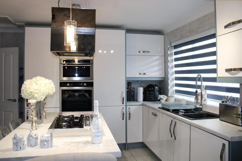 索利赫尔Stylish 4-Bedroom House near NEC/BHX的厨房配有白色橱柜和炉灶烤箱。