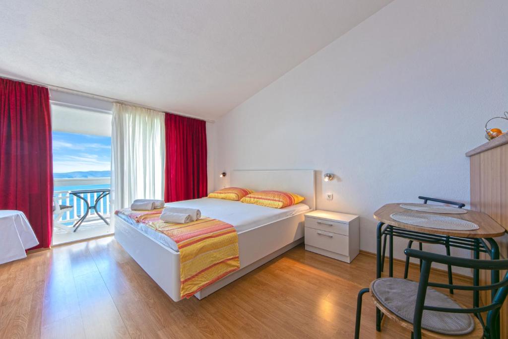 布雷拉Adria Brela Apartments的一间卧室设有一张床和一个阳台