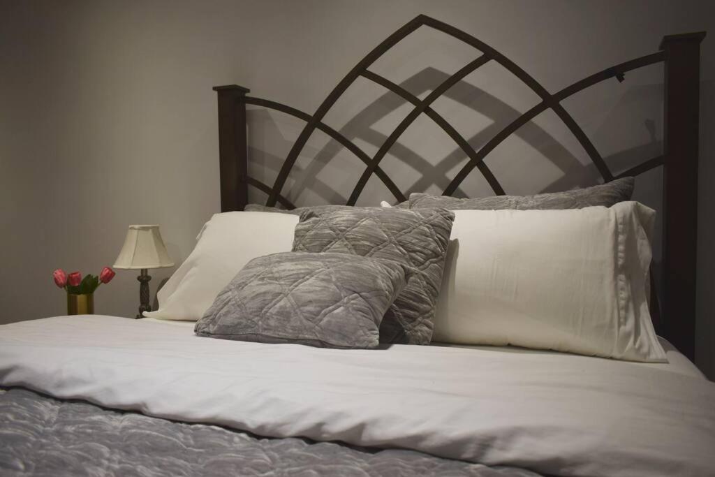 多伦多Home Away From Home - Basement Studio Apartment的床上铺有灰色和白色枕头的床