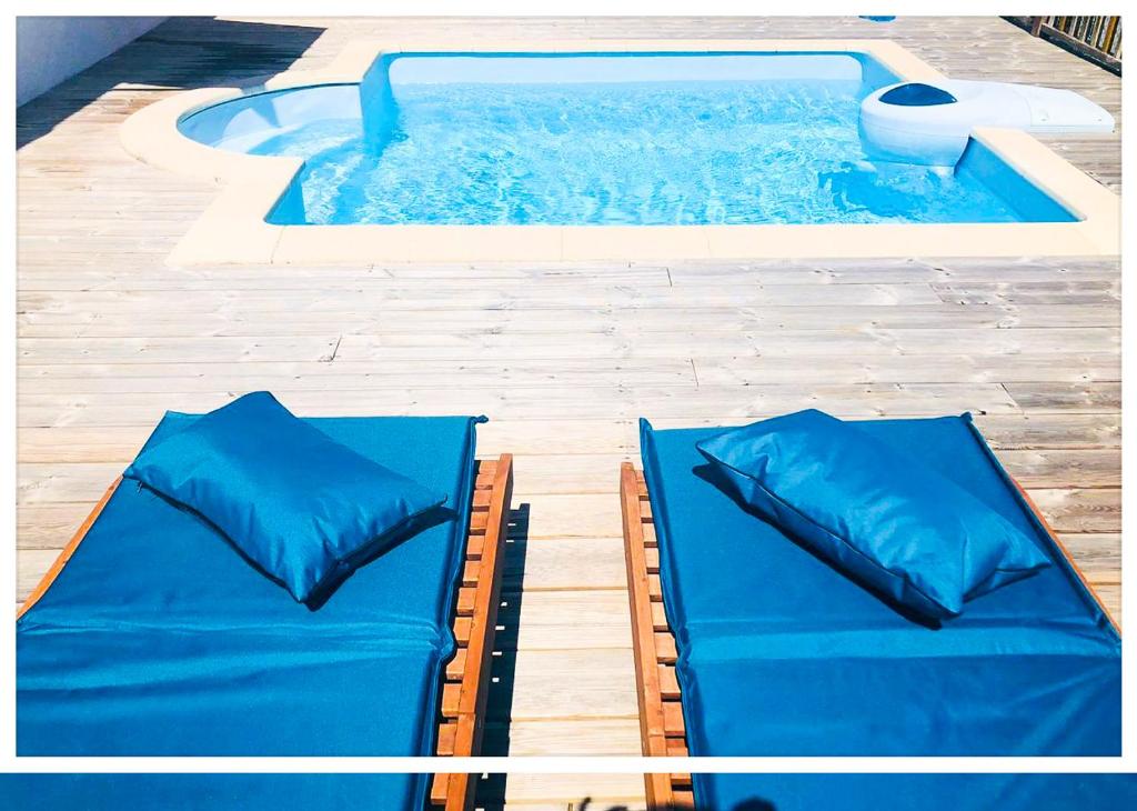 莱特鲁瓦西莱Villa GAIA的游泳池旁设有2张蓝色软垫床