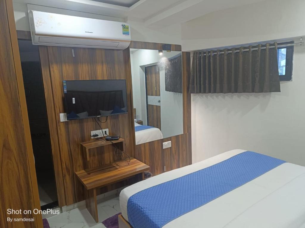 艾哈迈达巴德HOTEL ROYAL GRAND的一间卧室配有一张床、镜子和电视