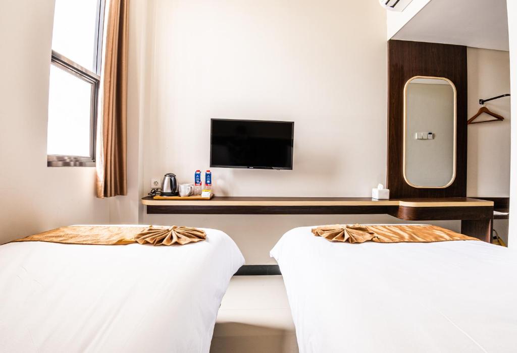 JomblangKIYANA HOTEL SEMARANG的一间酒店客房,设有两张床和电视